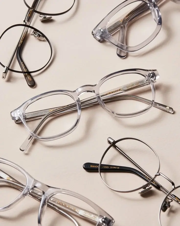 Monturas de gafas modernas en metal y acetato transparentes sobre fondo beige